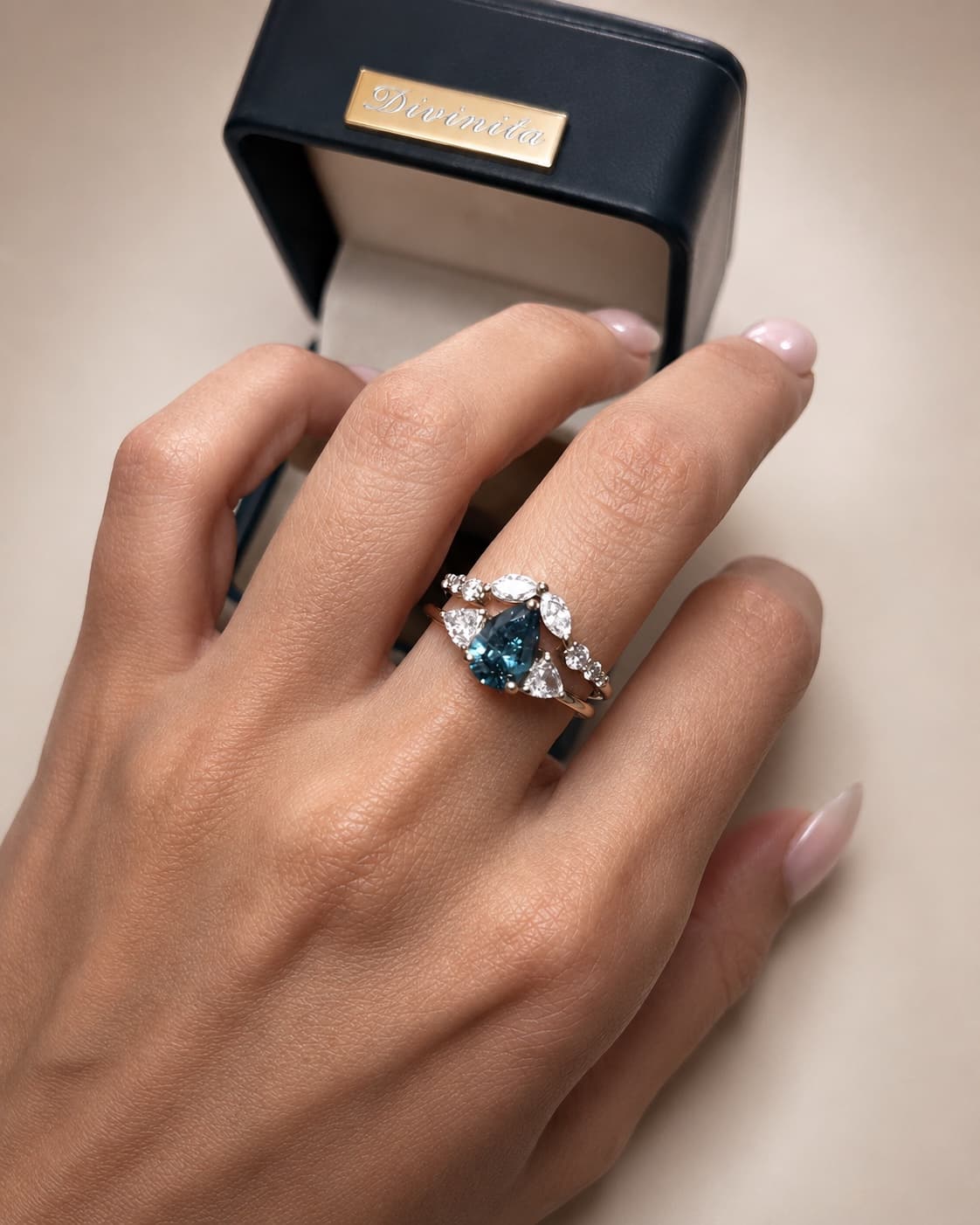 Anel Divinita em ouro champanhe com diamante azul pera e trillions brancos, com aro de encaixe de diamantes navete